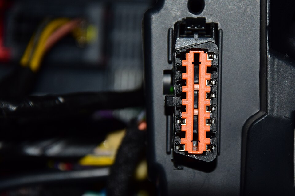 차량 대시보드 하단에 장착된 실제 OBD2 진단 포트 소켓 클로즈업